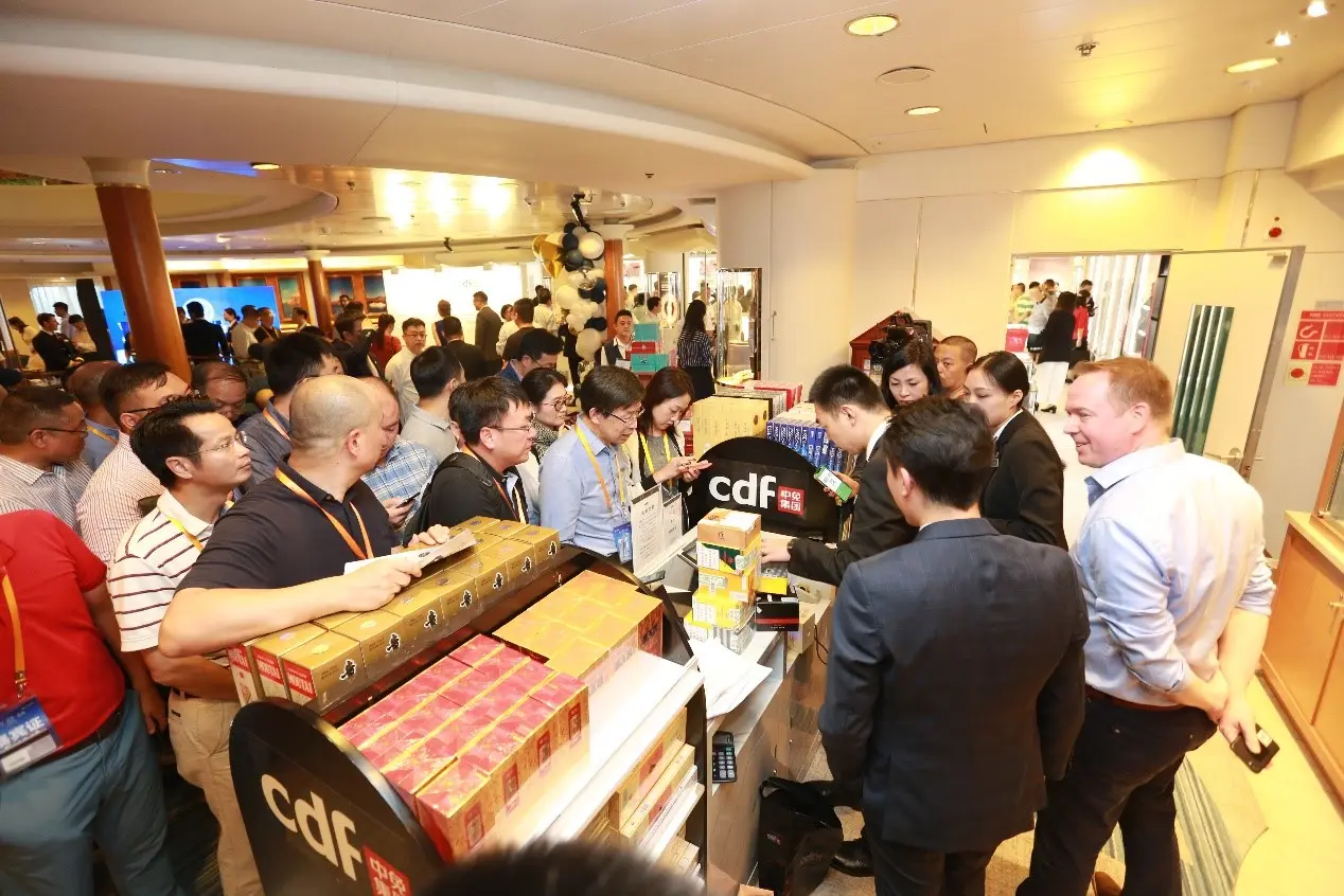 Crowded opening or retail-event photograph aboard the cruise environment.