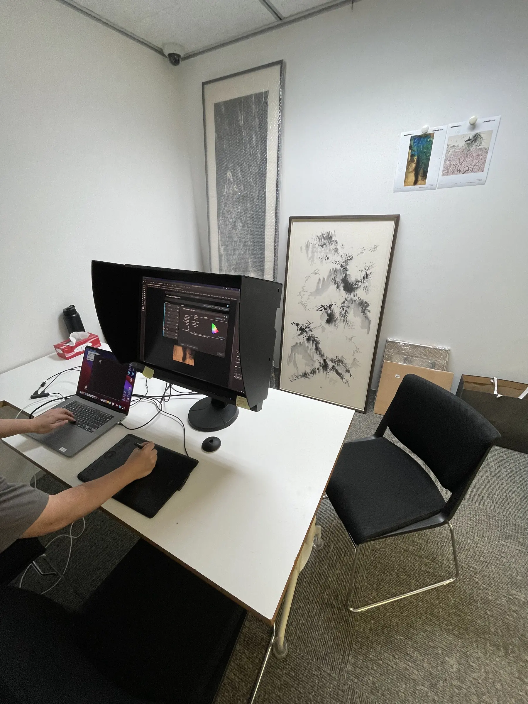Workstation with monitor and physical artwork in the review room.