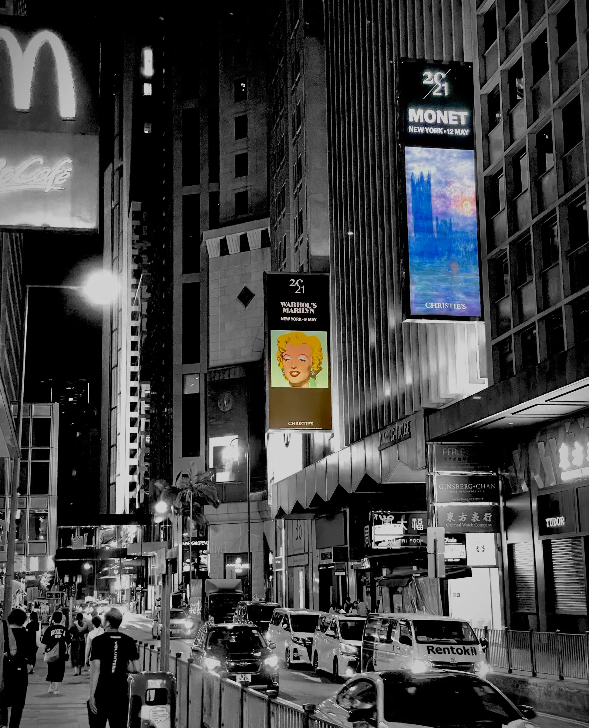 Black-and-white city view with vertical digital billboard.
